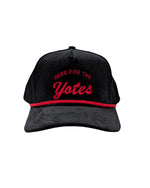 Black corduroy cap, with red rope and red embroidered 'HERE FOR THE Yotes.'