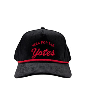Black corduroy cap, with red rope and red embroidered 'HERE FOR THE Yotes.'