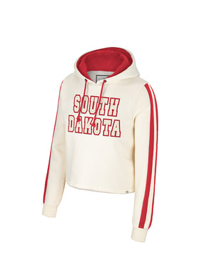 Women's cream cropped hoodie with vertical red stripes down each sleeve and words, 'SOUTH DAKOTA' in cream with red outline across the chest