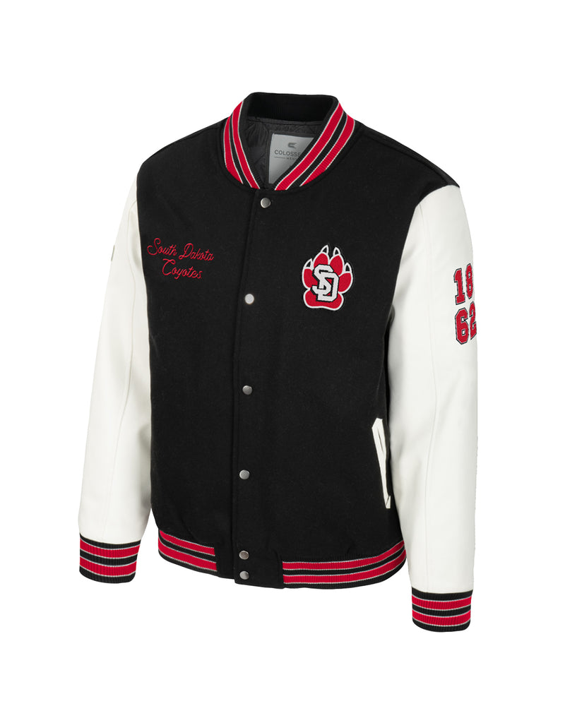 Black and white letterman's style jacket with red accents, SD Paw chenille patch, embroidered 'South Dakota Coyotes', 1862 on the faux leather whitesleeves.