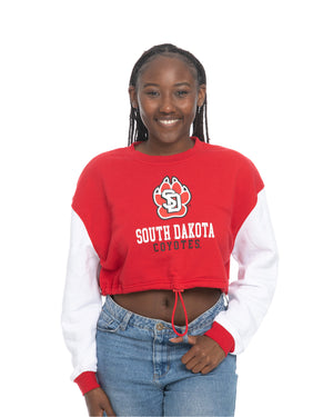 Young woman wearing the Zoozatz colorblock crew with white sleeves and red torso featuring a cinch at waist. Graphic features large full color SD Paw logo with, 'SOUTH DAKOTA COYOTES,' below.