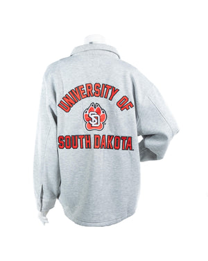 Back of gray women's shacket with red and black text, 'UNIVERSITY OF SOUTH DAKOTA,' and SD Paw logo in the middle. 