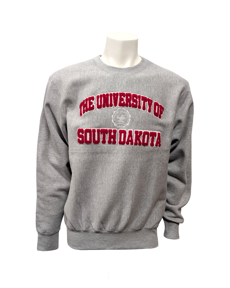 Gray crew with chenille red and white letters, 'THE UNIVERSITY OF SOUTH DAKOTA,' with white embroidered university seal in the center. 