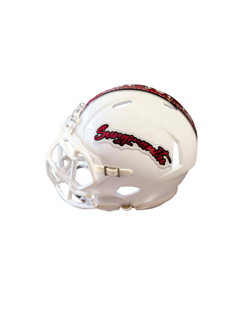 Side view of white mini football helmet with word 'Sungmanitu' on the side and a red stripe with Native American symbols on the top. 