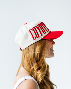 Side view showing wearing embroidered text 'COYOTES' starts.