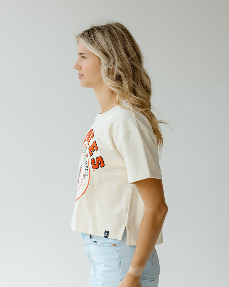 Side view of woman wearing oatmeal waist length tee.