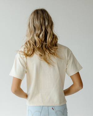 Back of woman wearing oatmeal tee.