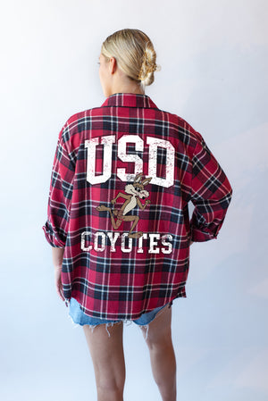 Red and black flannel with text on back that says, 'USD COYOTES' in white lettering and vintage Charlie running