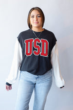 Black sweatshirt with white arms and red text,'USD' on chest 
