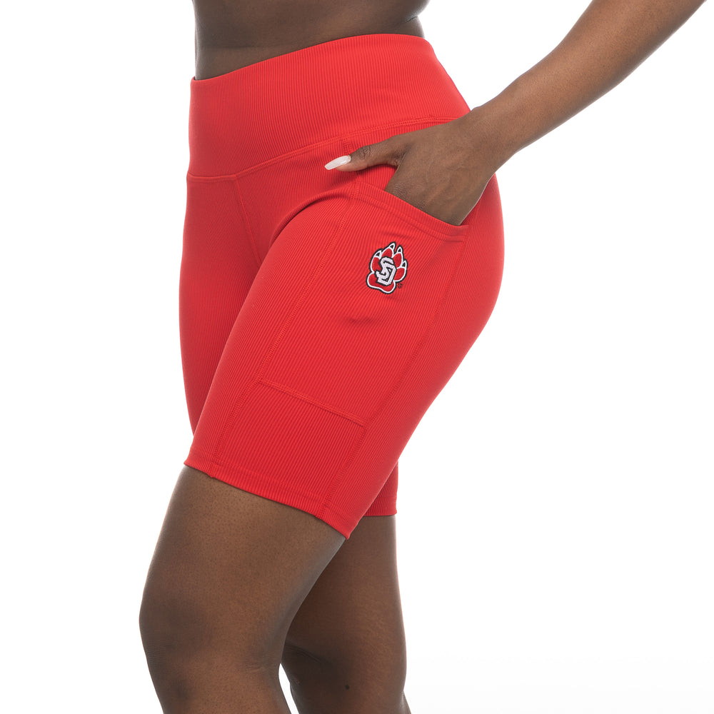 Model wearing red ribbed bike shorts with side pocket and SD Paw logo on left side of thigh.