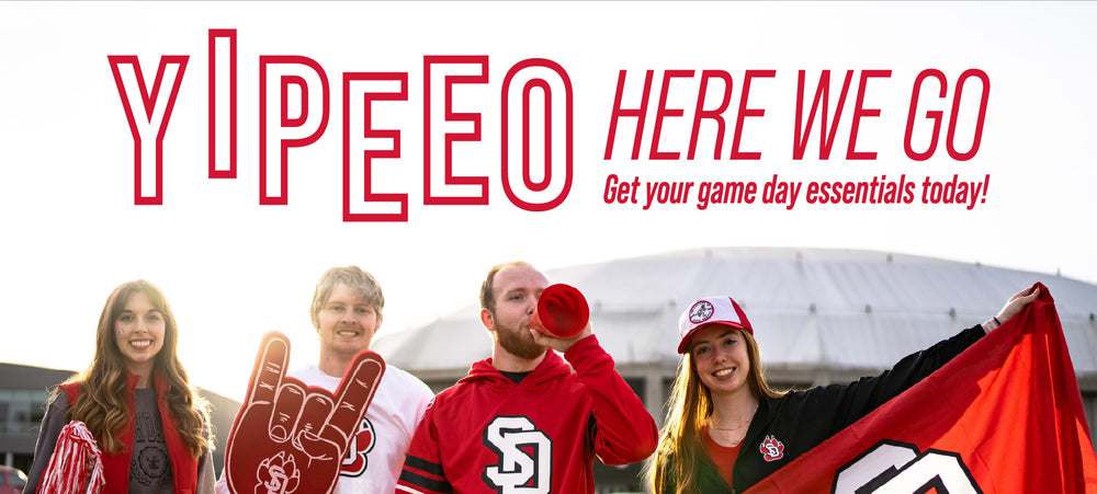 Group of fans in USD gear outside of the Dakota Dome with promotional text 'YIPEEO HERE WE GO Get your game day essentials today!'