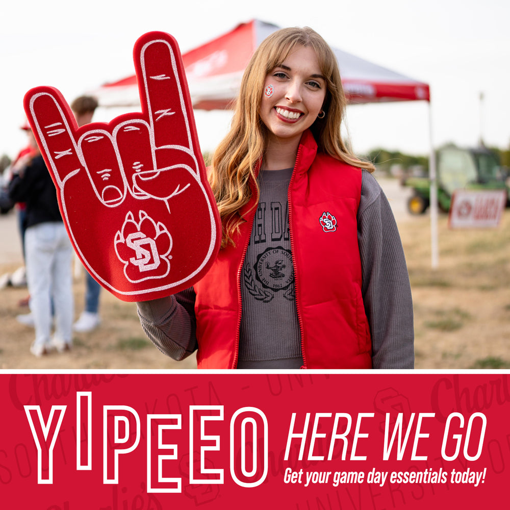 Red graphic with text, 'YIPEEO HERE WE GO Get your game essentials today!' and image of a young woman dressed in USD gear holding up a foam paw outside the Dome.