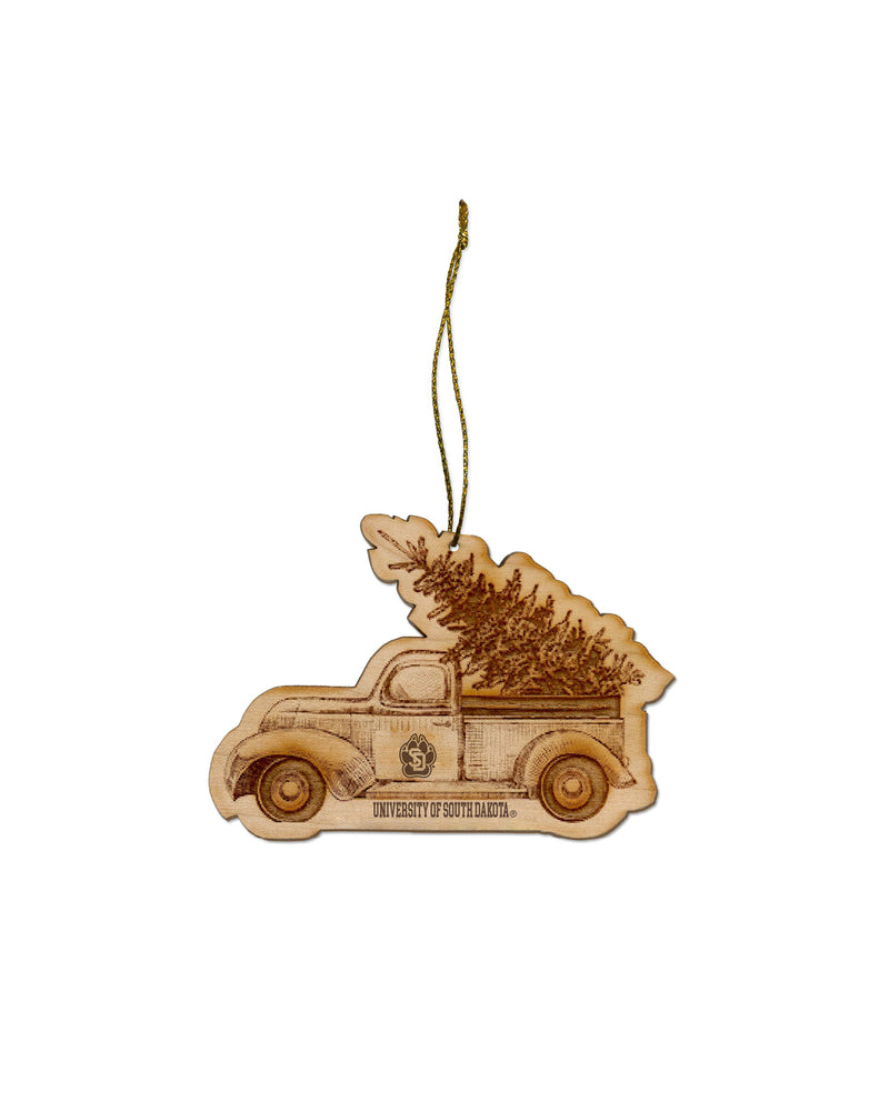 Flat wooden ornament of old truck with SD Paw logo on side carrying a Holiday tree in the back end and text below, 'UNIVERSITY OF SOUTH DAKOTA.'