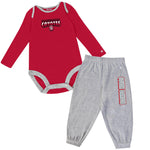 Red long-sleeve infant bodysuit with text across chest in black and white, 'UNIVERSITY OF SOUTH DAKOTA COYOTES,' and gray sweatpants with, 'SOUTH DAKOTA' down the left leg.